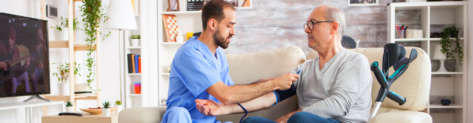 caregiver checking the blood pressure of the elderly man